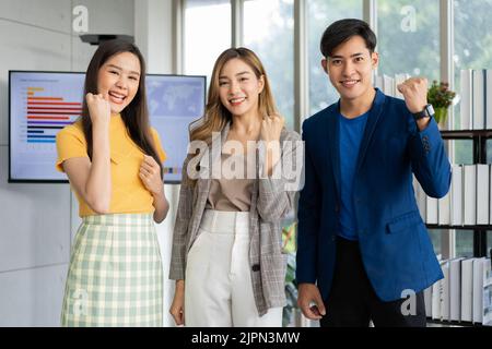 Group of Asia young entrepreneurs creative people looking at camera and excited for success project, working together in the office. Stratup business Stock Photo