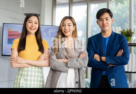 Group of Asia young entrepreneurs creative people looking at camera and smiling after brainstorming, working together in the office. Stratup business Stock Photo