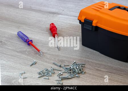 Screwdriver with Toolbox on Wooden Floor, screw. Stock Photo