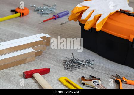Toolbox with Various Work Tools on Wooden Floor. Stock Photo