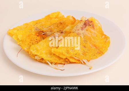 Banh xeo, Vietnamese Crêpes or Pancakes with pork, shrimp, onions, beasn sprouts inside, Vietnamese food isolated on white background. close-up Stock Photo