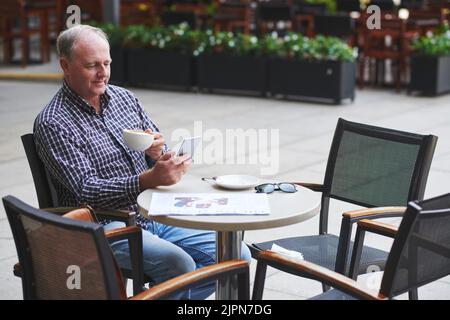 Senior man drinking coffee and videocalling to his family Stock Photo