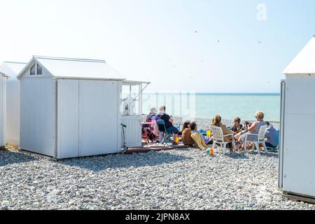 France, Somme, Picardie, Mers les Bains, beach with a group of people sitting in front of a beach cabin // France, Somme (80), Picardie, Mers les Bain Stock Photo