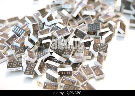Lots of radios. Loose electronic parts on the table. Digital indicator, LEDs, capacitor and microcircuits in a pile. Stock Photo