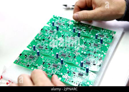 Electrical boards with parts for manual assembly of an electrical device. Digital indication. Manual assembly of radio components.. Stock Photo