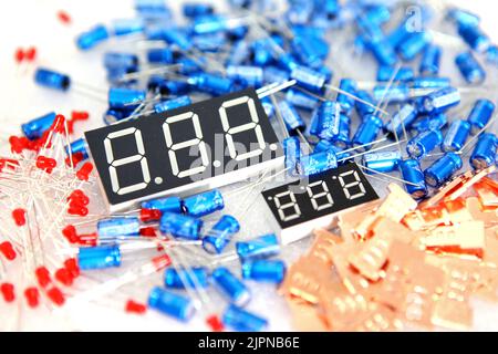 Lots of radios. Loose electronic parts on the table. Digital indicator, LEDs, capacitor and microcircuits in a pile. Stock Photo