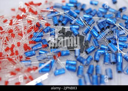 Lots of radios. Loose electronic parts on the table. Digital indicator, LEDs, capacitor and microcircuits in a pile. Stock Photo