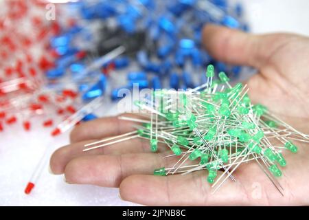Lots of radios. Loose electronic parts on the table. Digital indicator, LEDs, capacitor and microcircuits in a pile. Stock Photo