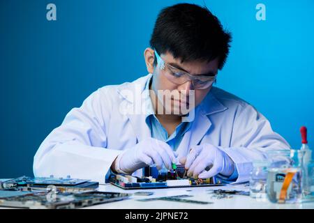 Young Vietnamese engineer working with electronic components Stock Photo