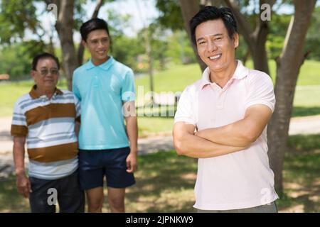 Happy middle-aged man and his father and son in the background Stock Photo