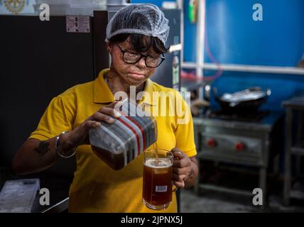 New Delhi, India. 19th Aug, 2022. A survivor of acid attack makes an ice tea at Sheroes Hangout cafe in Noida on the outskirts of New Delhi, India, Aug. 19, 2022. Sheroes Hangout is a cafe run by survivors of acid attacks. The cafe aims at empowering acid attack survivors, as well as raising awareness on the acid attacks. The cafe provides job opportunities for acid attack victims. Credit: Javed Dar/Xinhua/Alamy Live News Stock Photo