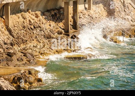 Big waves hitting the sea shore. Waves break on the stones. Stock Photo