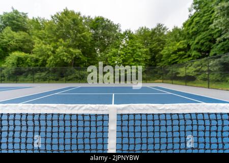 Over the net view of a new blue tennis court with white