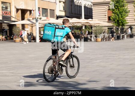 Belgrade-Serbia - June 15, 2022: Wolt delivery food service courier fast riding a bike on city street Stock Photo