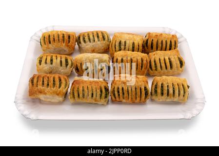 Baked puff pastry stuffed with spinach and cheese on white cardboard tray isolated on white, clipping path Stock Photo