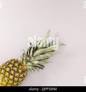 Fresh ripe pineapple on grey backgorund. Flat lay. Summer fruits concept Stock Photo