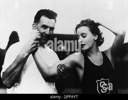 1925 , USA : The  movie actress  GRETA GARBO ( 1905 - 1990 ) in a pubblicity photo with the athletic theacher of University of Southern California   - MOVIE - CINEMA - portrait - ritratto  - muscoli - muscles - biceps - bicipiti - canottiera - braccio - arm - fitness   ----  Archivio GBB Stock Photo