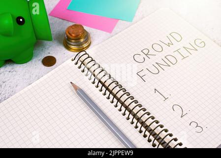 Text sign showing Crowd Funding, Business overview Fundraising Kickstarter Startup Pledge Platform Donations Important Message On Notebook On Desk Wit Stock Photo