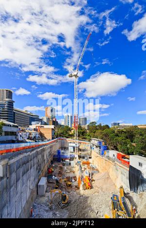 Deep excavated pit on construction site with crane and machinery developing high-rise residential building in Sydney. Stock Photo