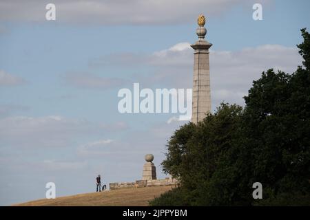 Coombe Hill, Buckinghamshire, UK. 19th August, 2022. A man walks past Butler's Cross today on another warm but windy day as the ongoing drought continues. Credit: Maureen McLean/Alamy Live News Stock Photo
