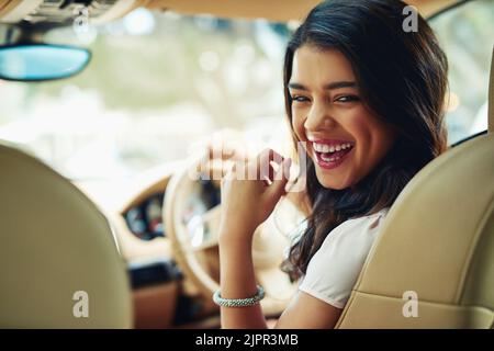 Enjoying her new car. an attractive young woman driving a car. Stock Photo
