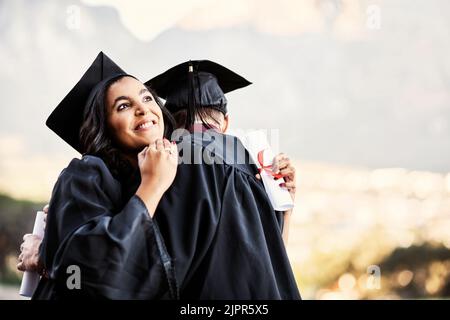 We did it. two students hugging each other on graduation day. Stock Photo