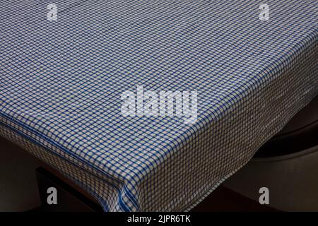 Blue and white chequered tablecloth on corner of empty table Stock Photo