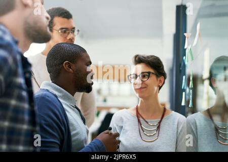 We are proud of our plans. a group of designers brainstorming with notes on a glass wall in an office. Stock Photo