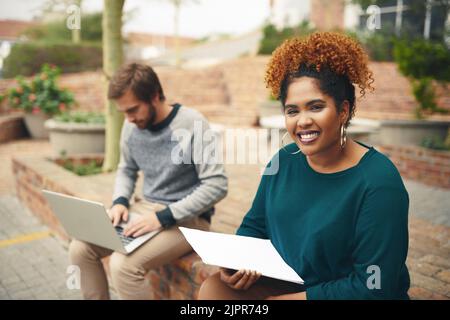 Exams are approaching and Ill be ready. High angle shot of two young university students studying on their campus grounds. Stock Photo