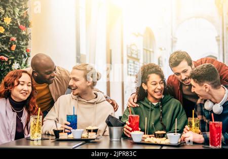 Friends group drinking and eating at coffee bar restaurant - People talking and having fun together at fashion cafeteria - Friendship concept with hap Stock Photo