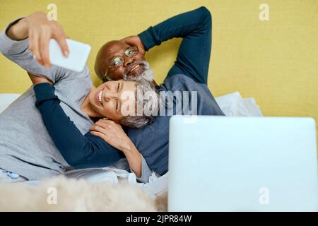 Fun times indoors with the love of my life. a senior married couple taking a selfie at home. Stock Photo