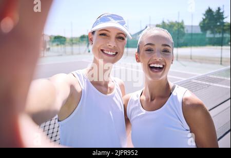 Selfie taking team of female tennis players on the court after a game, match or tournament portrait. Fit sporty teammates, athletes or professionals Stock Photo