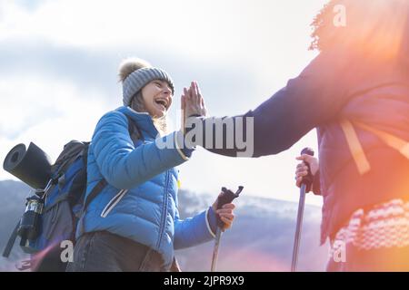 Give me five. Joyful satisfied funny hikers holding hands up smiling and gesticulating - Discovery Travel Destination Concept Stock Photo
