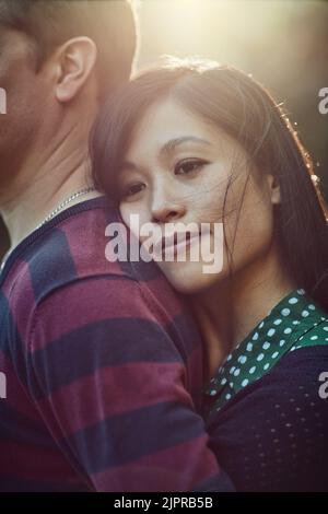 Love is the softest pillow to rest ones head on. an affectionate young couple spending time together outdoors. Stock Photo