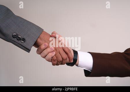 Hands of two businessmen holding each other. The hands of elegant men. Businessmen closing a deal. Hands on white background holding each other. High quality photo Stock Photo