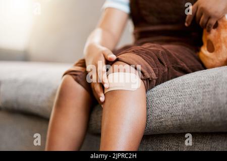Child with plaster or bandaid, injured and hurt by accident while playing a sport, exercise or outside closeup. Kid with a medical bandage after help Stock Photo
