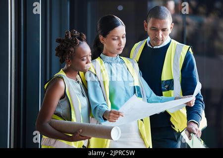 Construction, architect plans and diverse engineers consulting and planning a design as a team. Group of creative, professional and successful Stock Photo