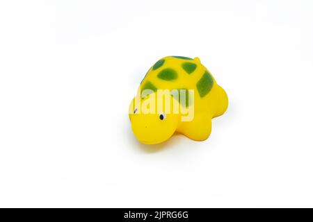 A closeup shot of a yellow-colored plastic tortoise toy isolated on a white background Stock Photo