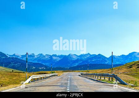 Asphalt road high in the Pyrenees Mountain range on beautiful summer day at ski resort Pla de Beret Stock Photo