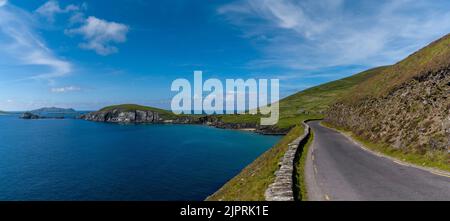 panorama landscape with Wild Atlantic Way coastal road leading to Slea Head on Dingle Peninsula in County Kerry of western Ireland Stock Photo