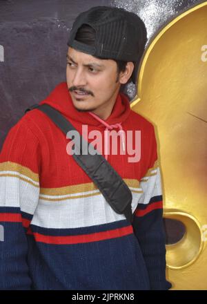 Waist-up of a young guy wearing cap backwards with looking sideways while standing Stock Photo