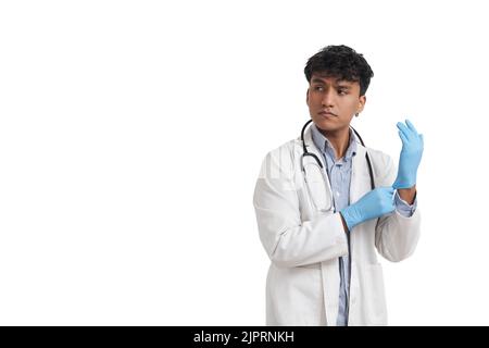 Young peruvian male doctor wearing blue gloves, isolated. Stock Photo