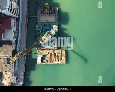 Floating crane dredging barges working on the construction of a marina. Aerial top view Stock Photo