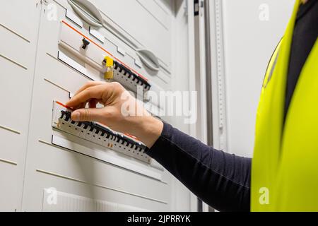 Close-up of male Technician Checking Electric Fuse Board In Server Room Stock Photo