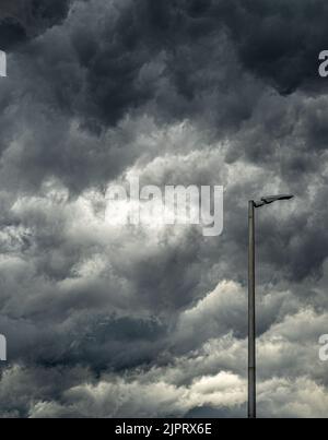 Lamppost before an immensity of clouds before a storm Stock Photo