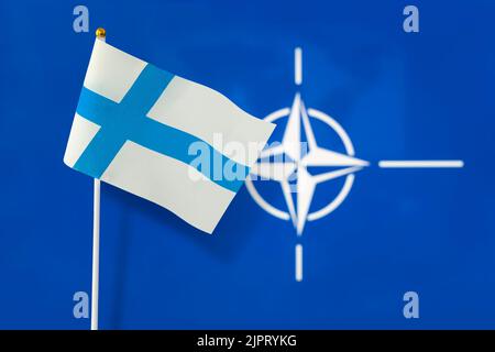 Flag of finland and the Flag of NATO, The largest defense alliance in the world, The concept of extending the borders of the North Atlantic alliance w Stock Photo