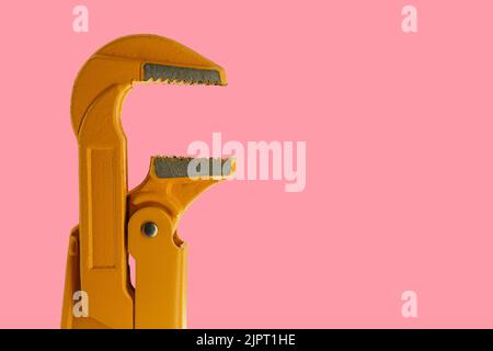 orange plumber wrench on a pink background. pipe wrench Stock Photo