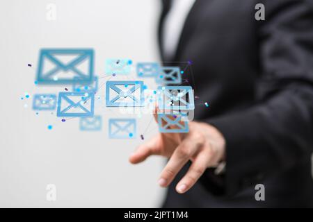 A man tapping floating 3D rendered black mail icons Stock Photo