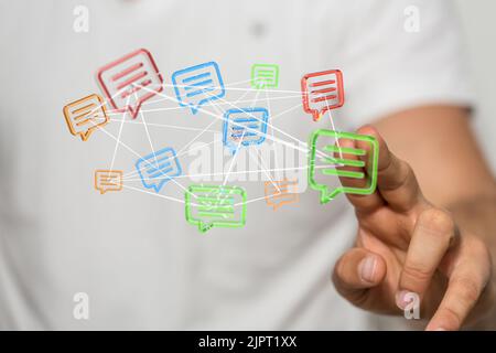 A man tapping a floating 3D rendered colorful message icons Stock Photo
