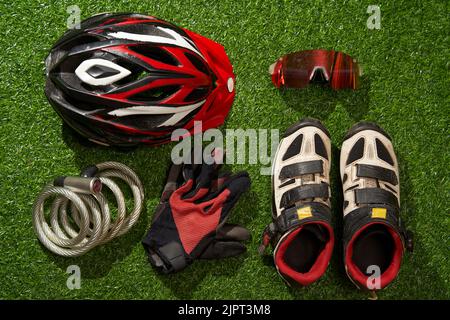 Flat lay composition with different cycling accessories on green grass background. Concept of sport lifestyle. Stock Photo